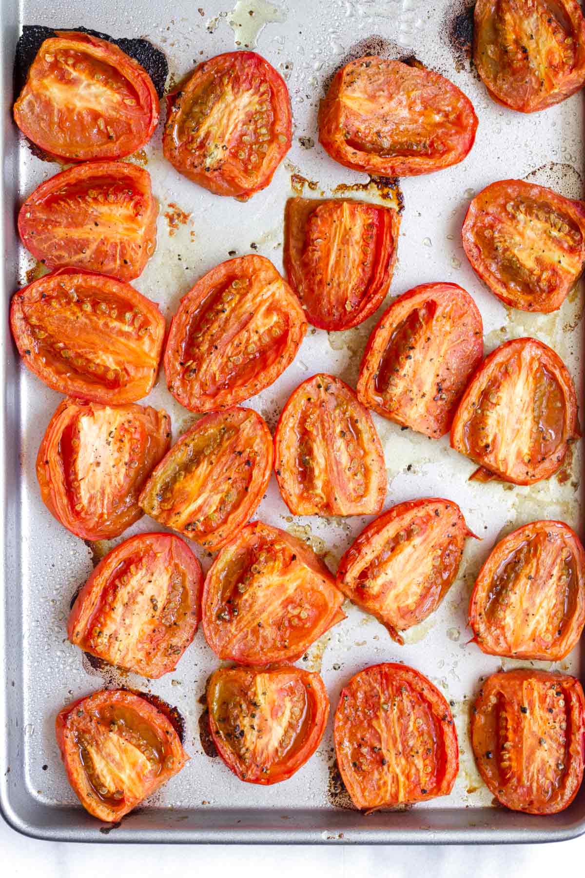 roasted roma tomato halves on a sheet pan