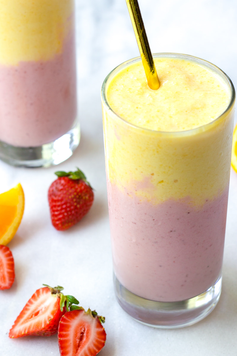 berry and mango smoothie with golden straw
