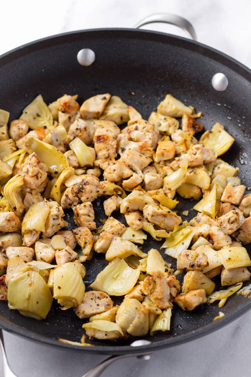 Sauteed cubed chicken breasts with artichokes on a non stick skillet