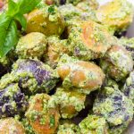 Close up of baby potato salad with pesto and basil leaves