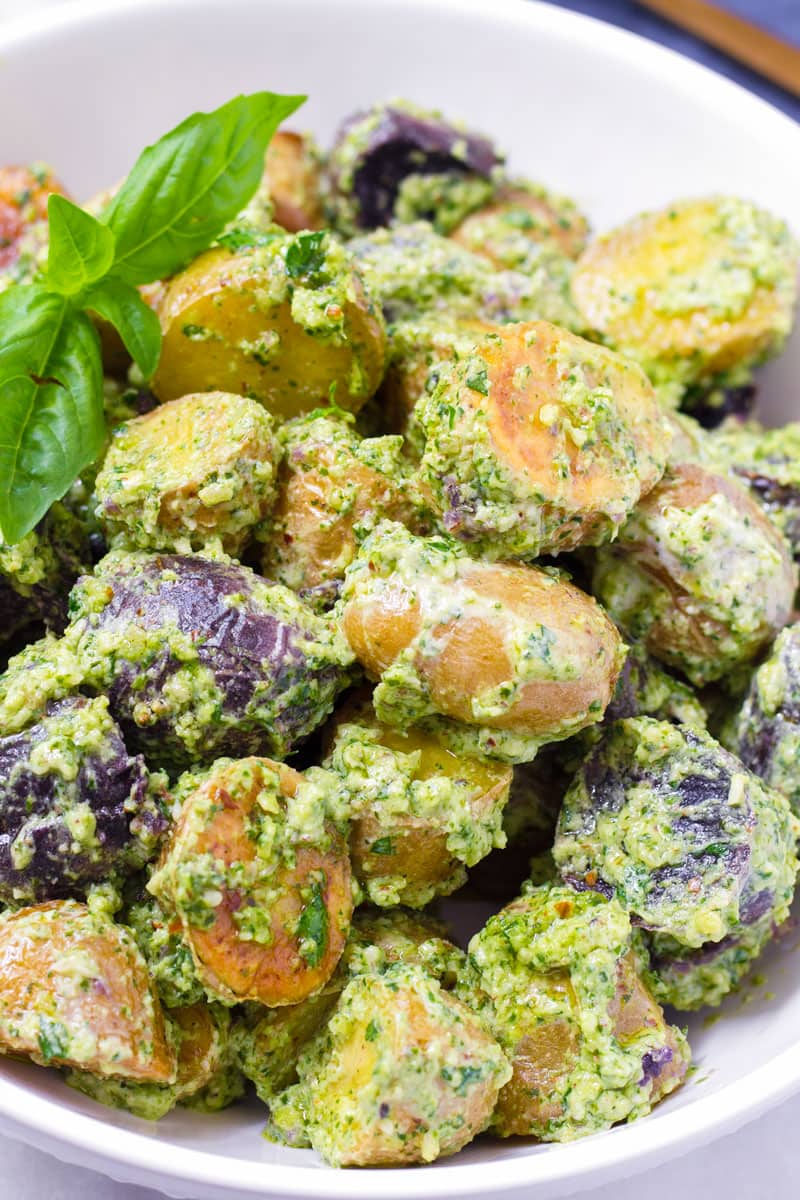 Close up of baby potato salad with pesto and basil leaves