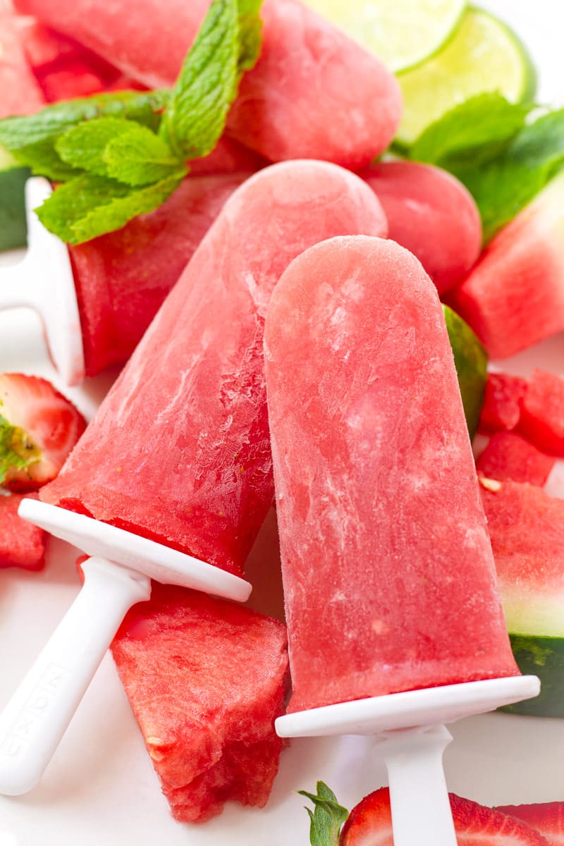 Two red watermelon ice treats with strawberries