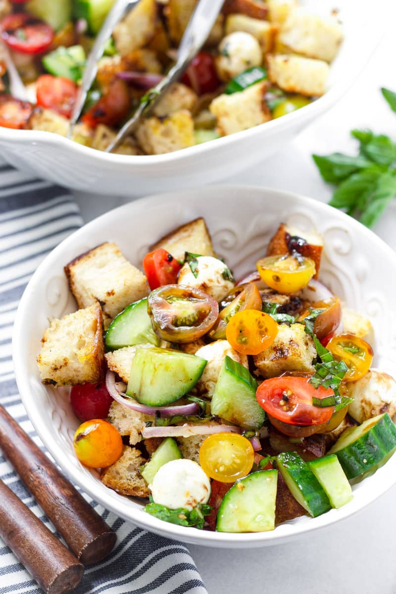 Individual serving of tomato, bread, cucumber, and mozzarella salad in a bowl