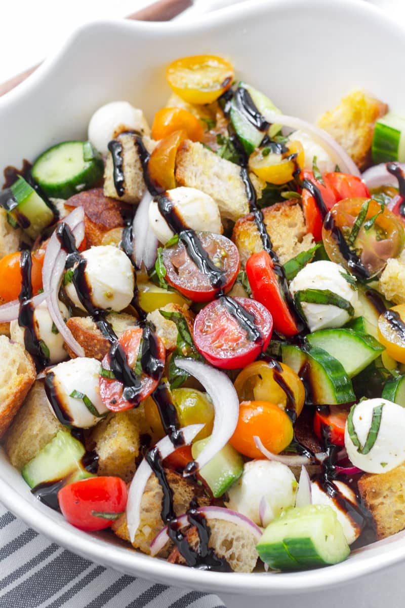 Large bowl with classic panzanella salad drizzled with balsamic glaze