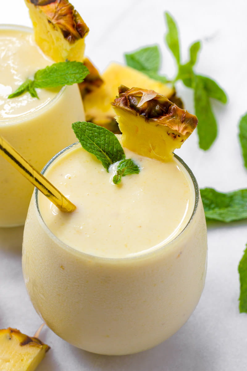 Tropical smoothies with fresh fruit and pineapple and mint garnish
