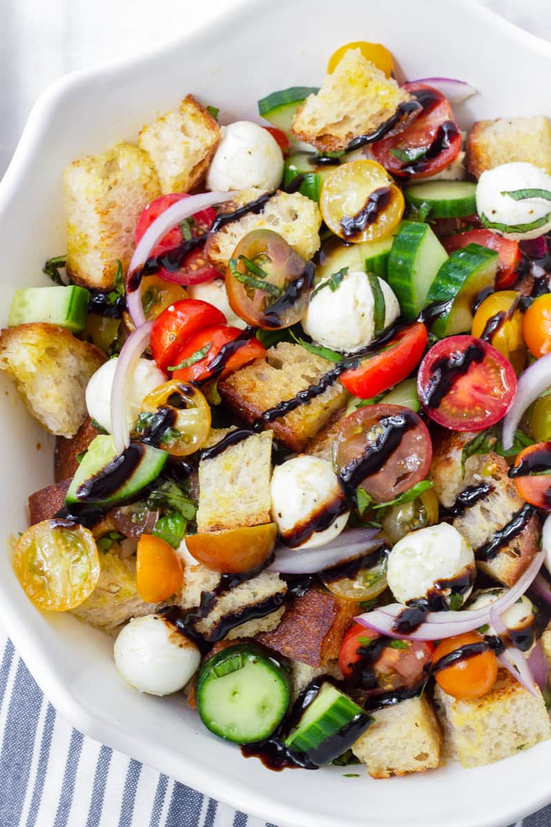 Top view of tomato and bread salad with balsamic glaze drizzle