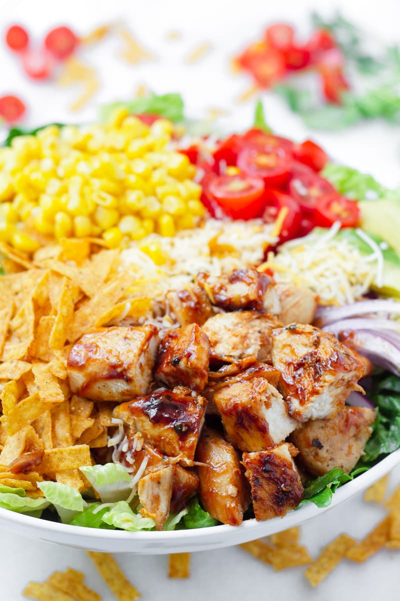 close up of grilled chicken salad, corn, tomatoes, tortillas chips, and bbq sauce