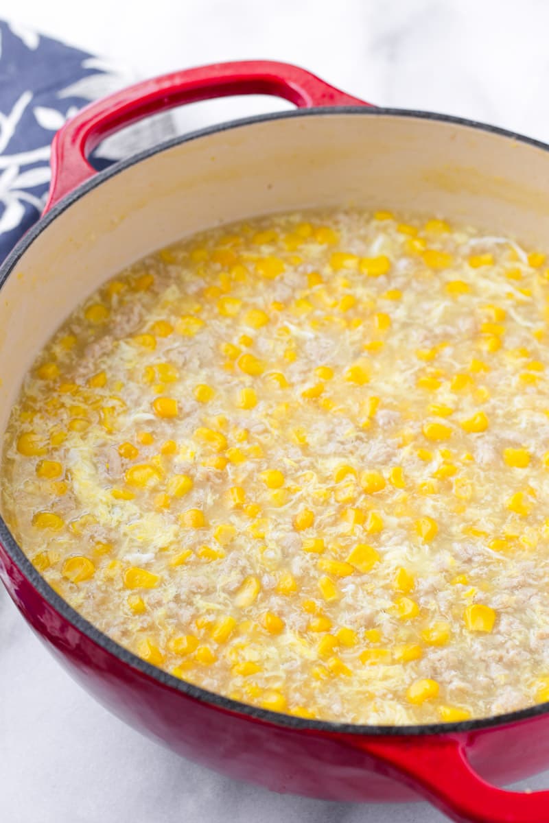 Red cast iron pot with Asian corn chowder