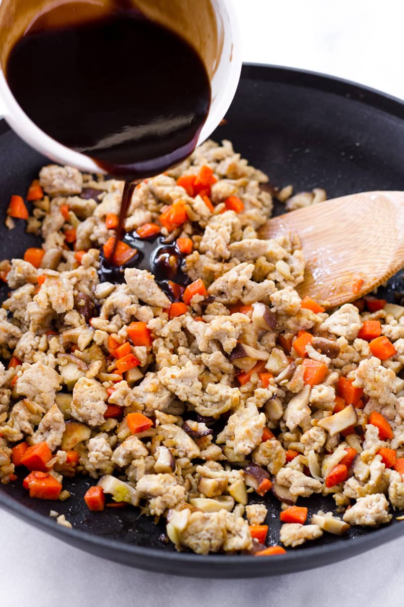 Sauce being poured over cooked ground chicken filling