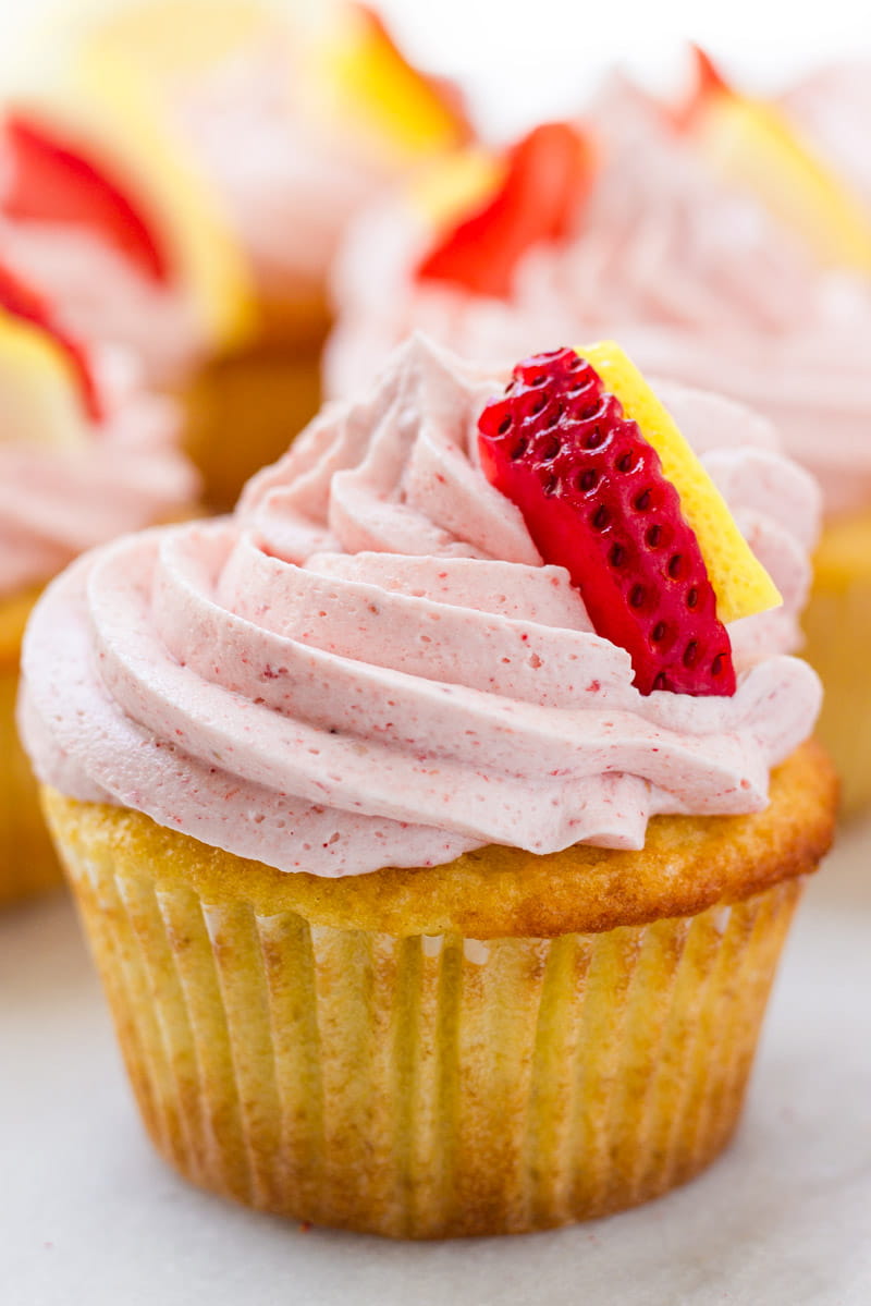 Close up of lemon cupcake with strawberry frosting decorated