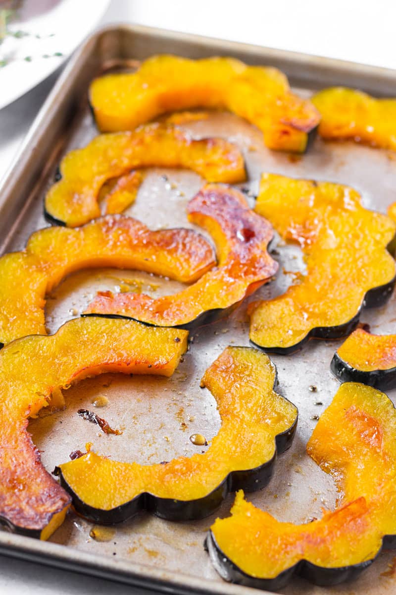 cooked and roasted acorn squash slices on sheet pan