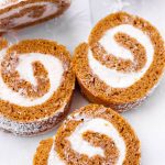 three slices of pumpkin roll laying on parchment paper