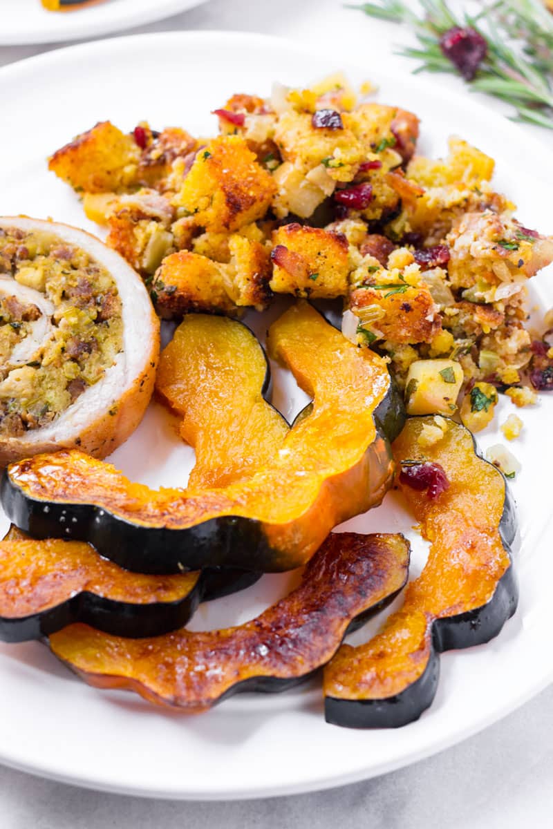 a Thanksgiving dinner plate with squash, stuffing, and turkey roulade