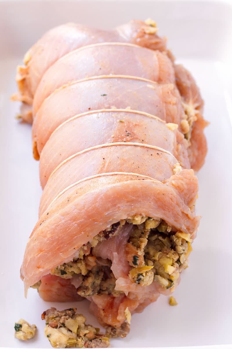 Prepared uncooked stuffed turkey breast tied with kitchen twine