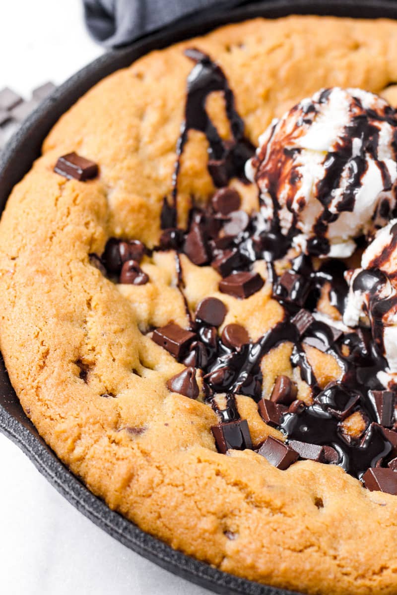 close of the the crispy and golden edges of a giant chocolate chip cookie in a skillet