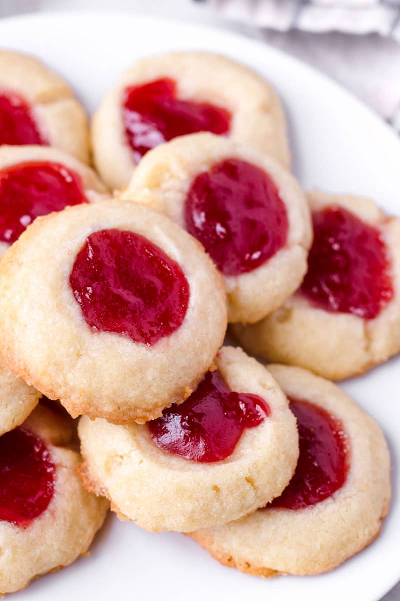 close up of raspberry thumbprint cookies on a plate