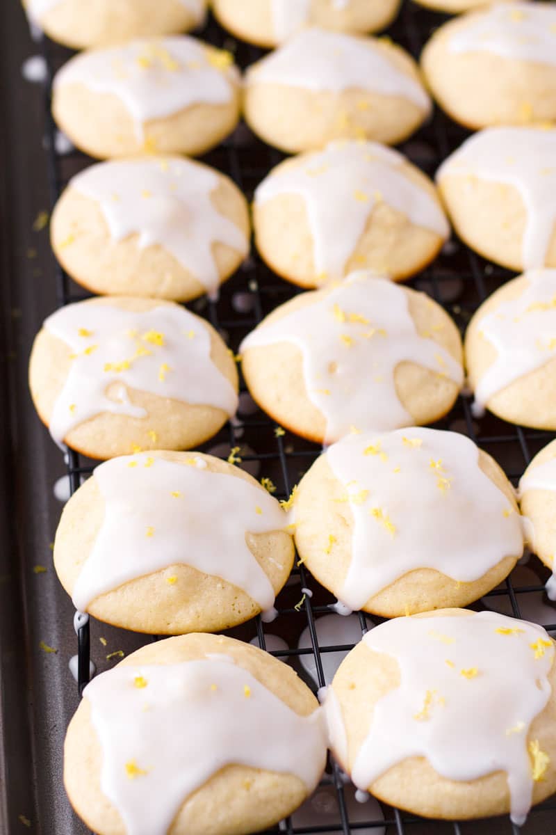 Several soft lemon glazed cookies lined up in a cooling rack