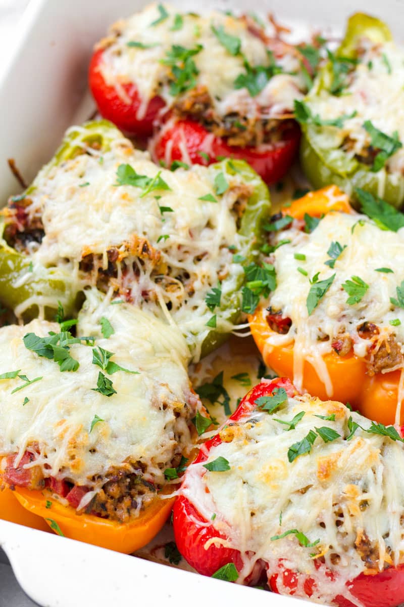 close up view of baked bell peppers with a meat and rice filling and topped with cheese