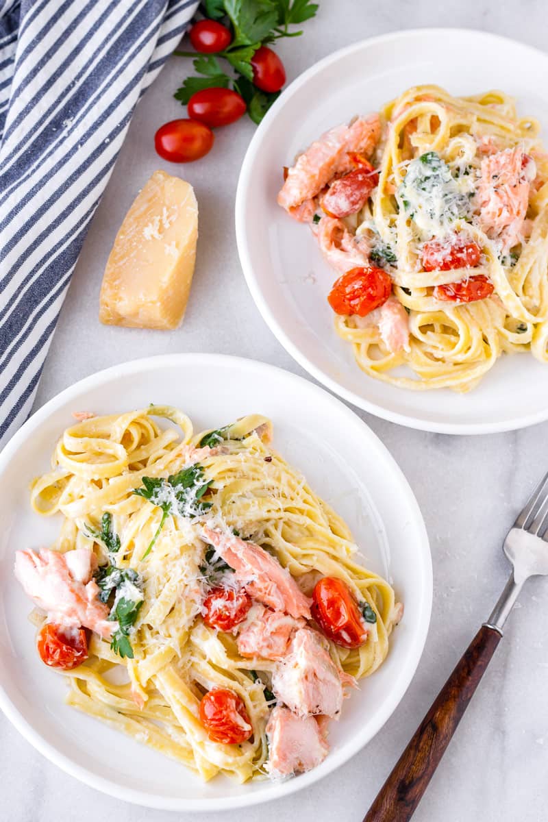 fettuccine with flaked roasted salmon served in two round plates