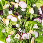 top view of fresh salad with asparagus, peas, lettuce, radishes, artichokes, and greens