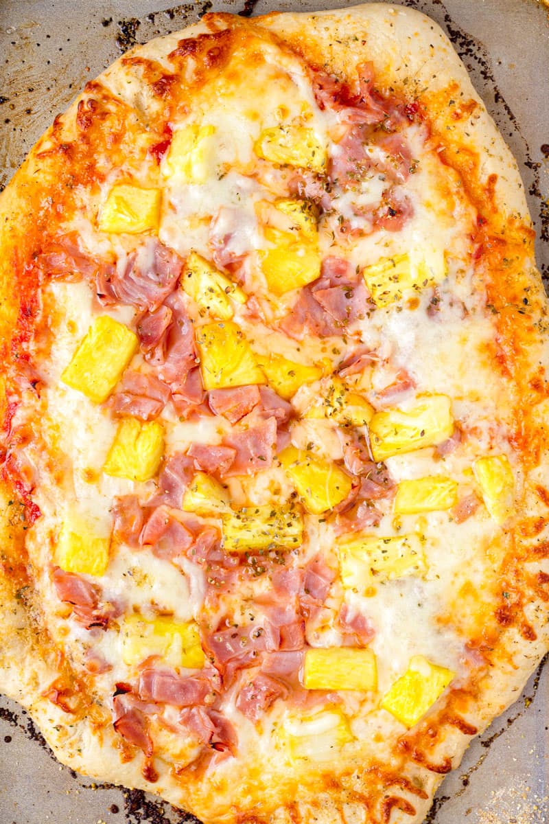 top view of baked homemade hawaiian pizza with fresh pineapples