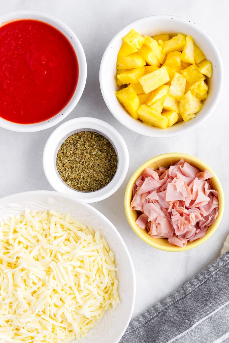 ingredients for hawaiian pizza in arranged in bowls