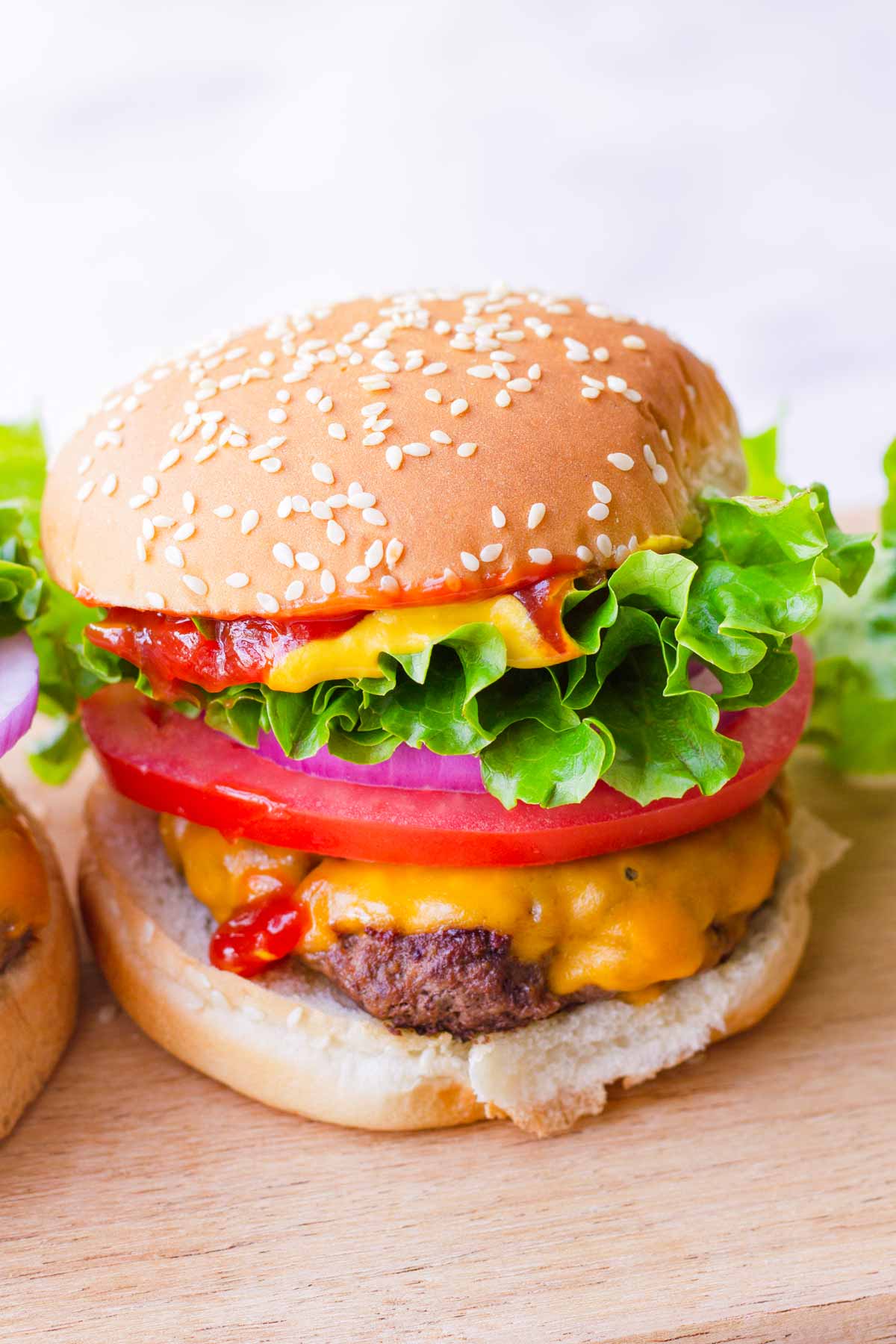 A classic American burger with cheese, lettuce, tomato, and onions