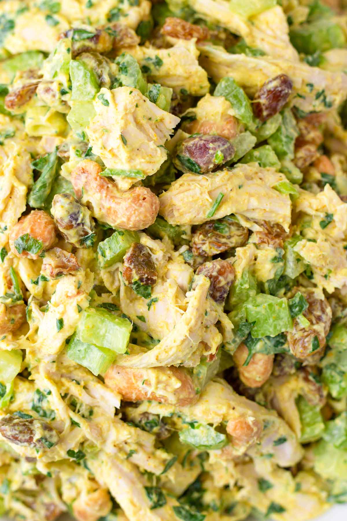 close up of golden chicken curry salad with raisins