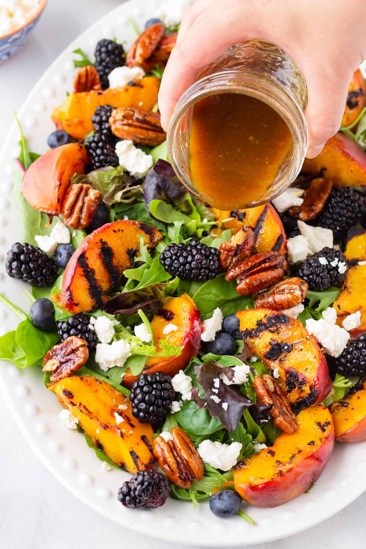 drizzling balsamic dressing onto salad