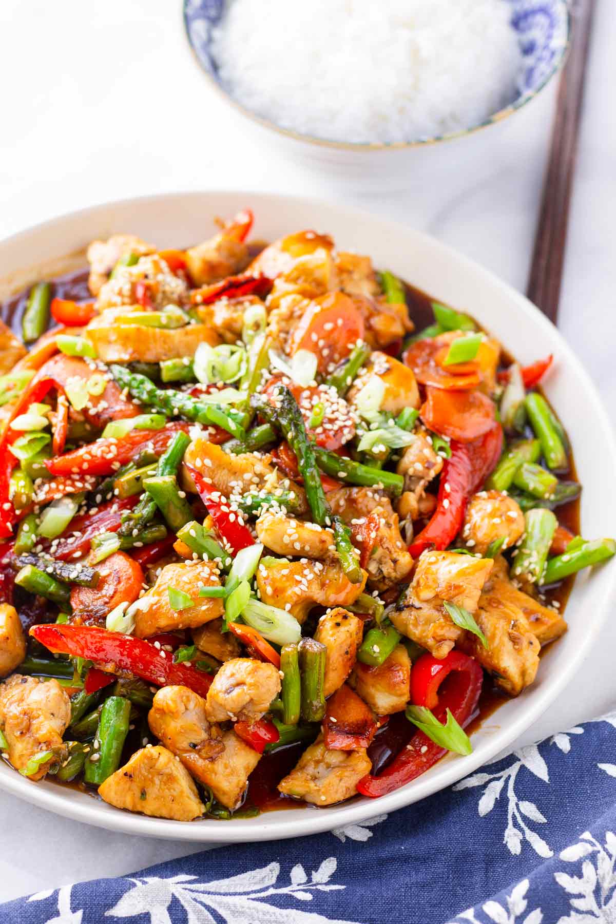 family style sized serving of chicken, asparagus, red bell peppers with sauce