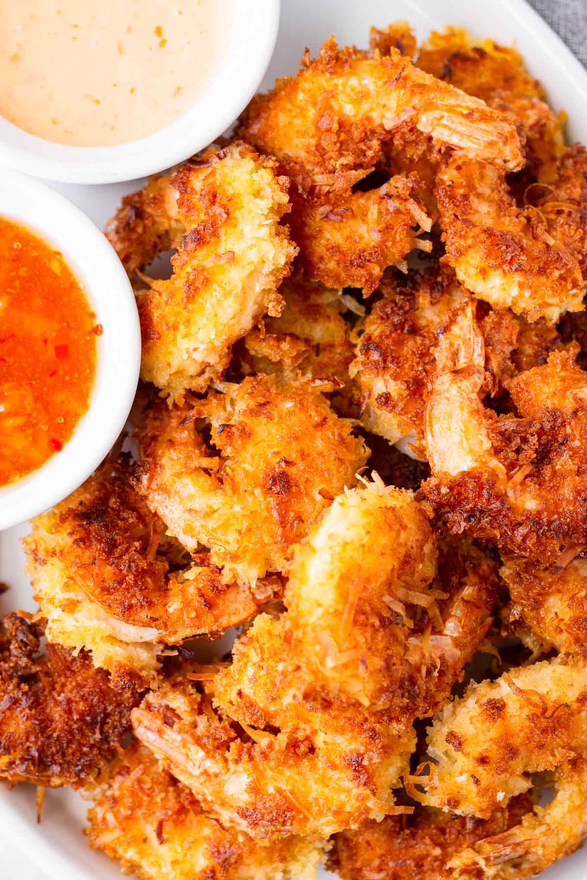 stacked fried shrimp with coconut and panko breading on a plate