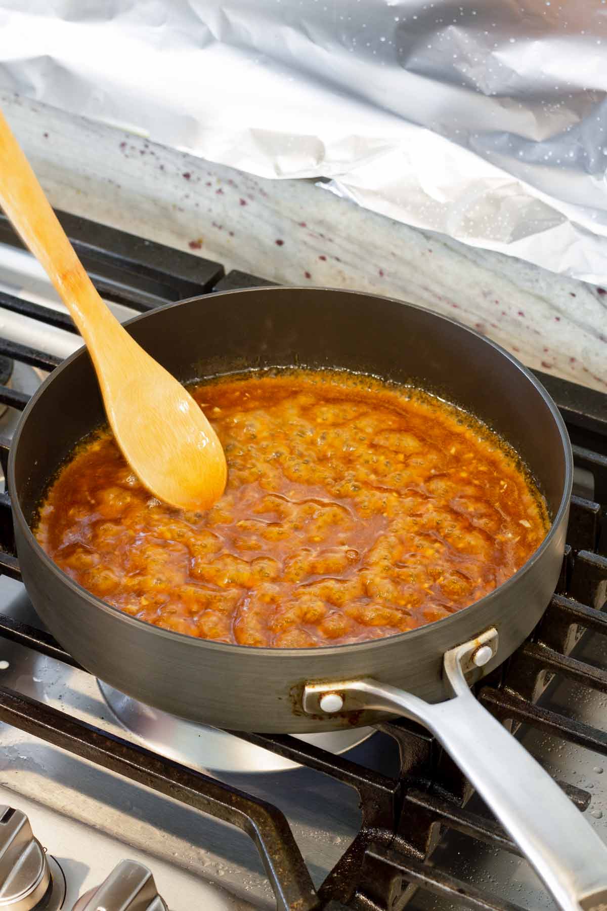 simmering the sauce in a skillet over the stove