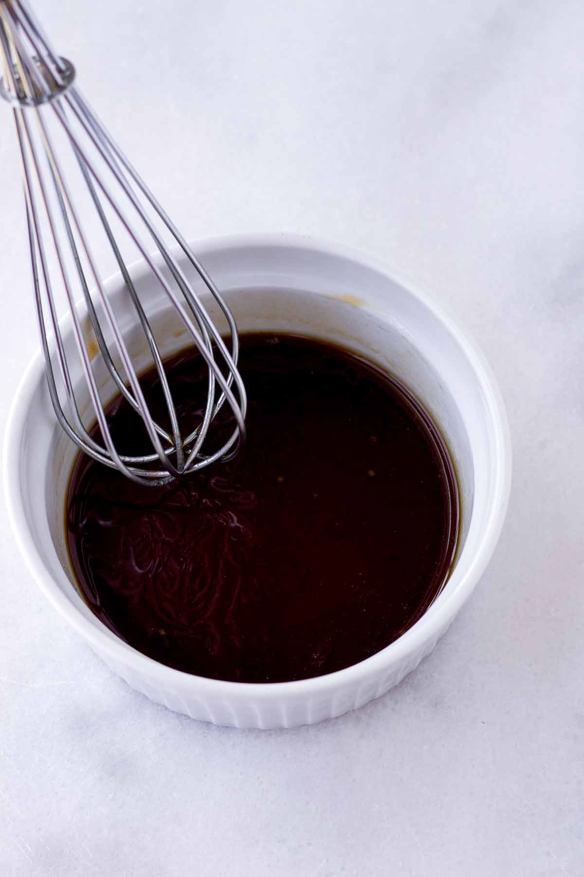 soy sauce and oyster sauce mix in a ramekin with a whisk