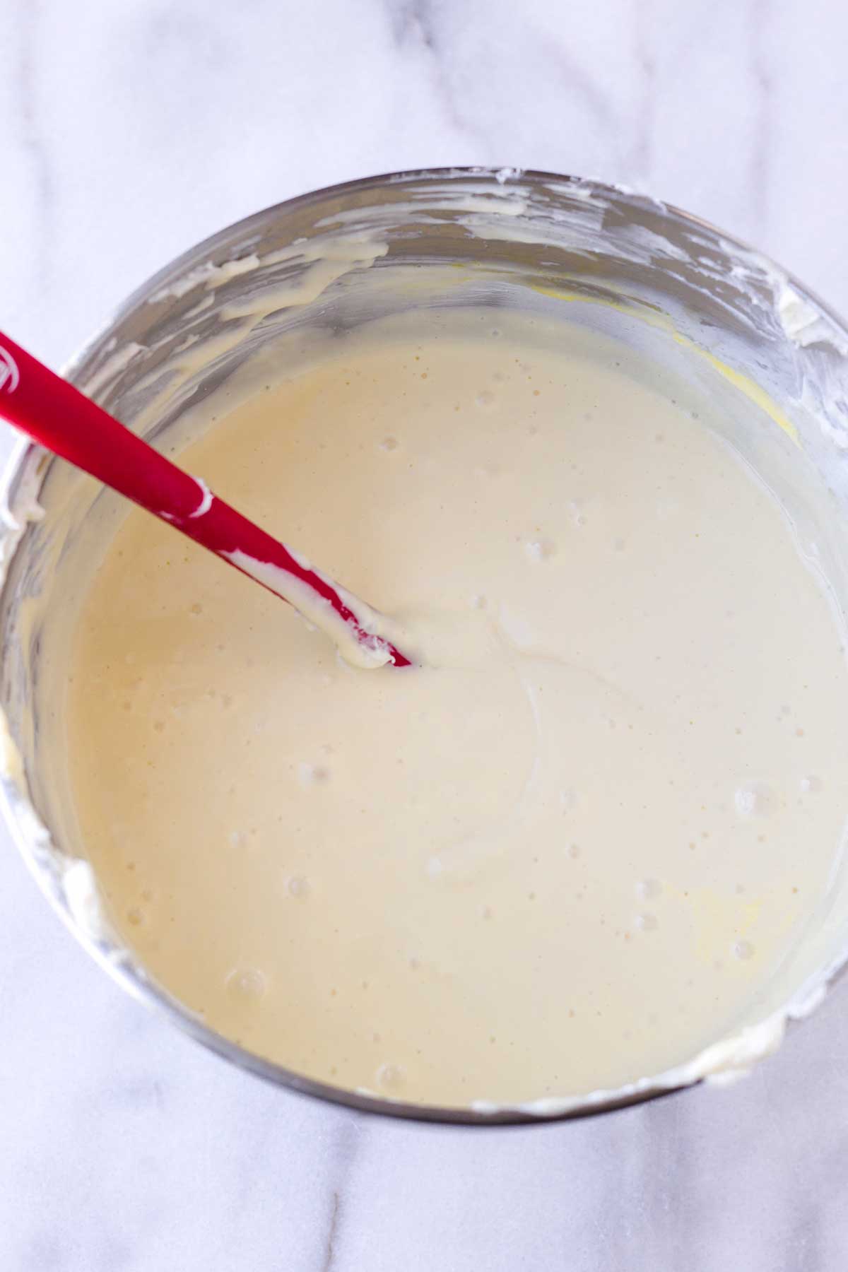 creamy cream cheese batter with a red spatula