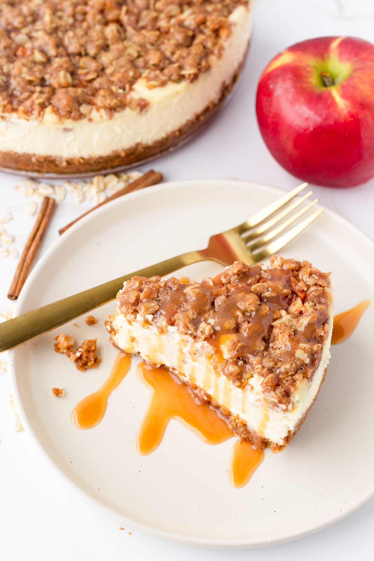a slice of apple crisp cheesecake with oats on a plate