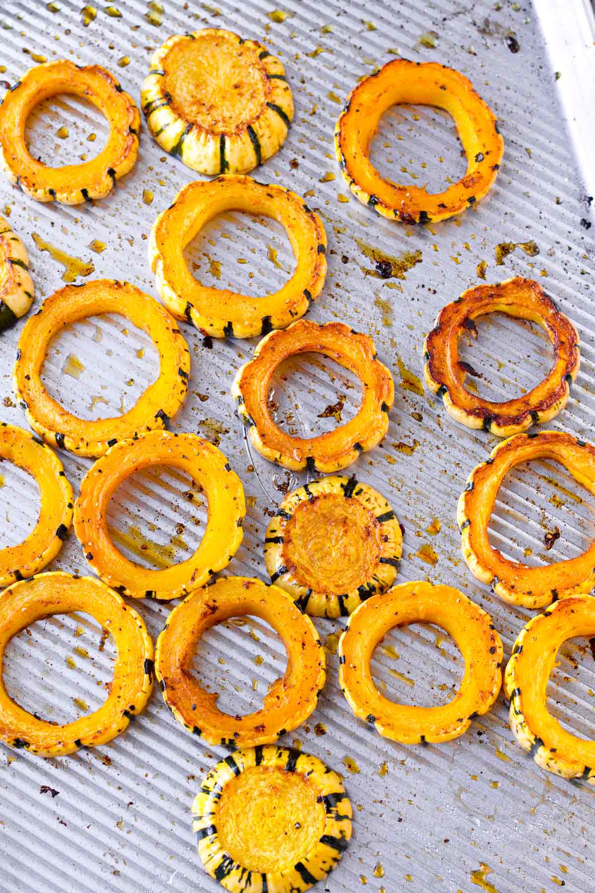 golden brown rings of delicata squash on a large sheet pan
