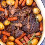 top view of dutch oven pot roast with thyme and vegetables