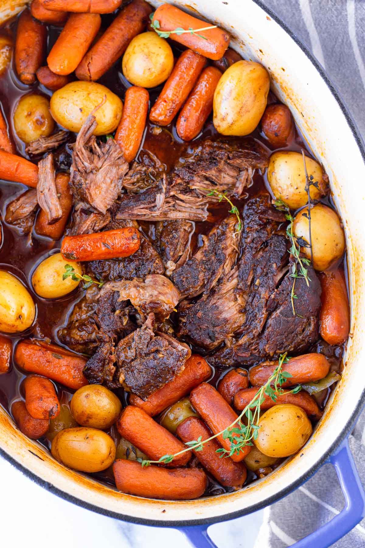 top view of dutch oven pot roast with thyme and vegetables