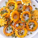 roasted and golden brown rings of delicata squash with thyme and pepitas