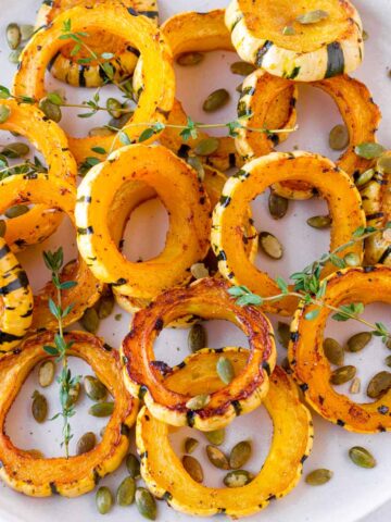 roasted and golden brown rings of delicata squash with thyme and pepitas