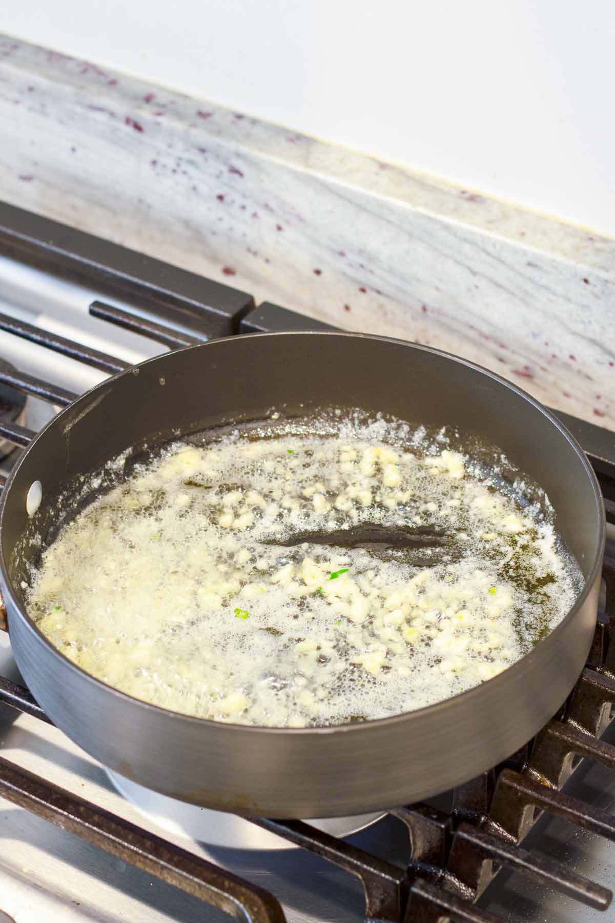 sauteeing minced garlic in butter over skillet