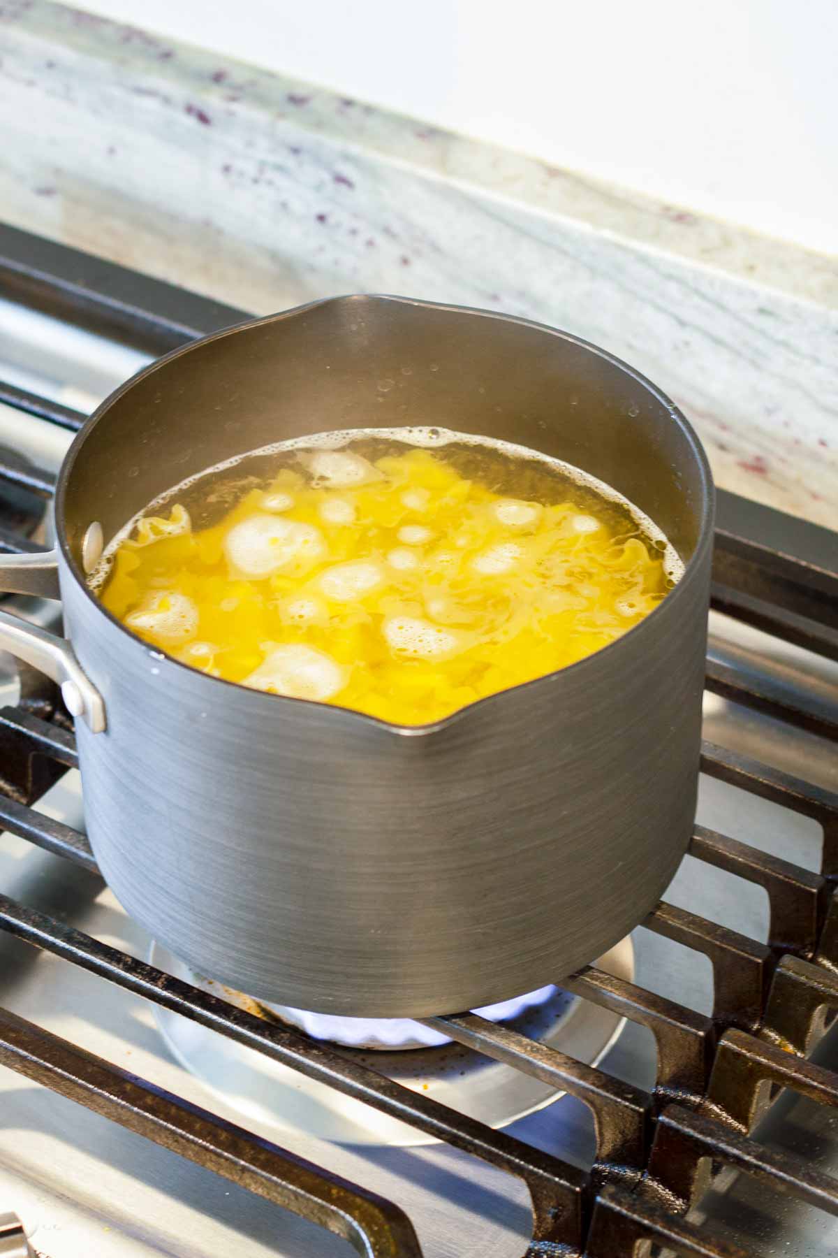 cooking pasta al dente in a pot over stovetop