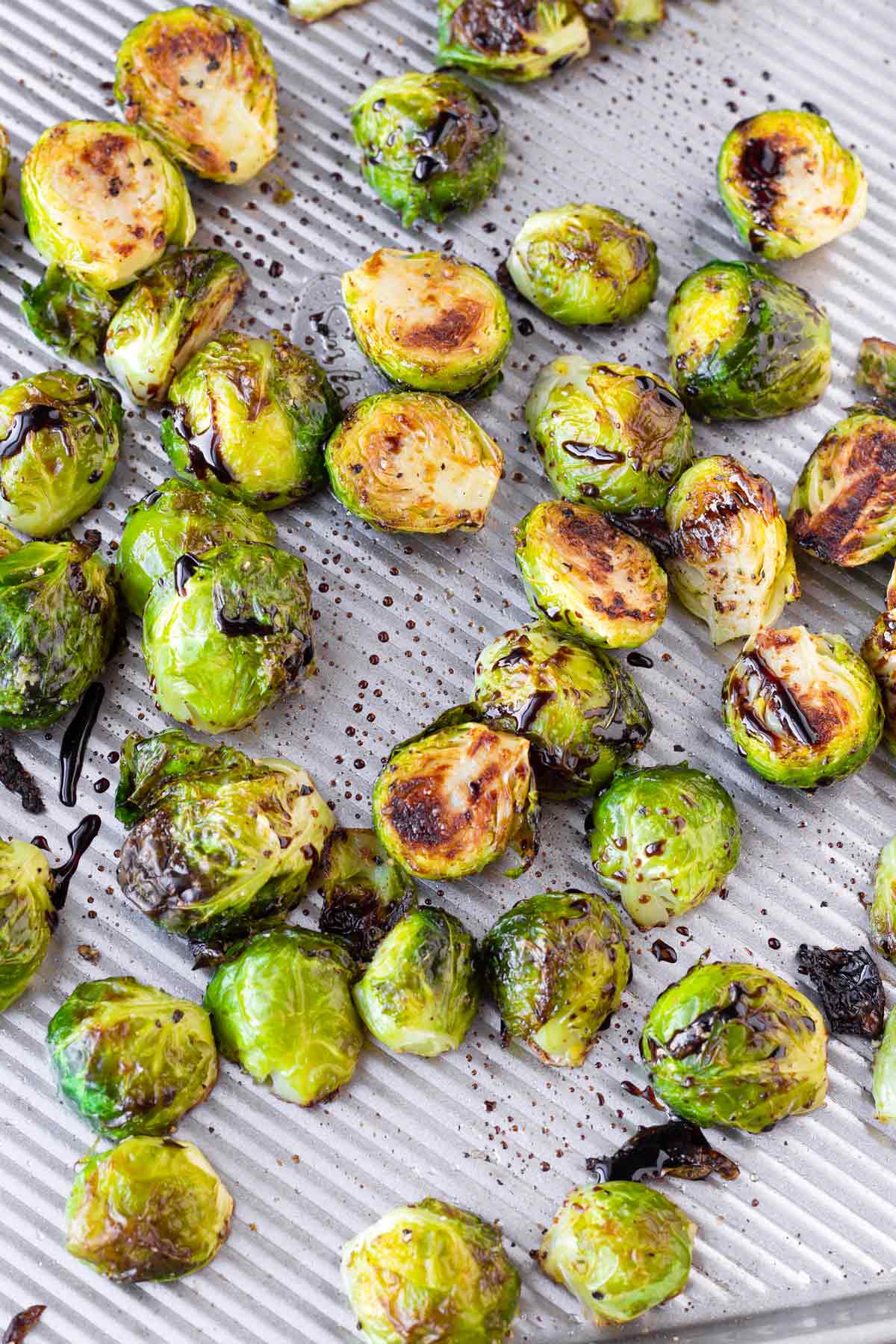 brussels sprouts tossed with thick balsamic glaze on sheet pan