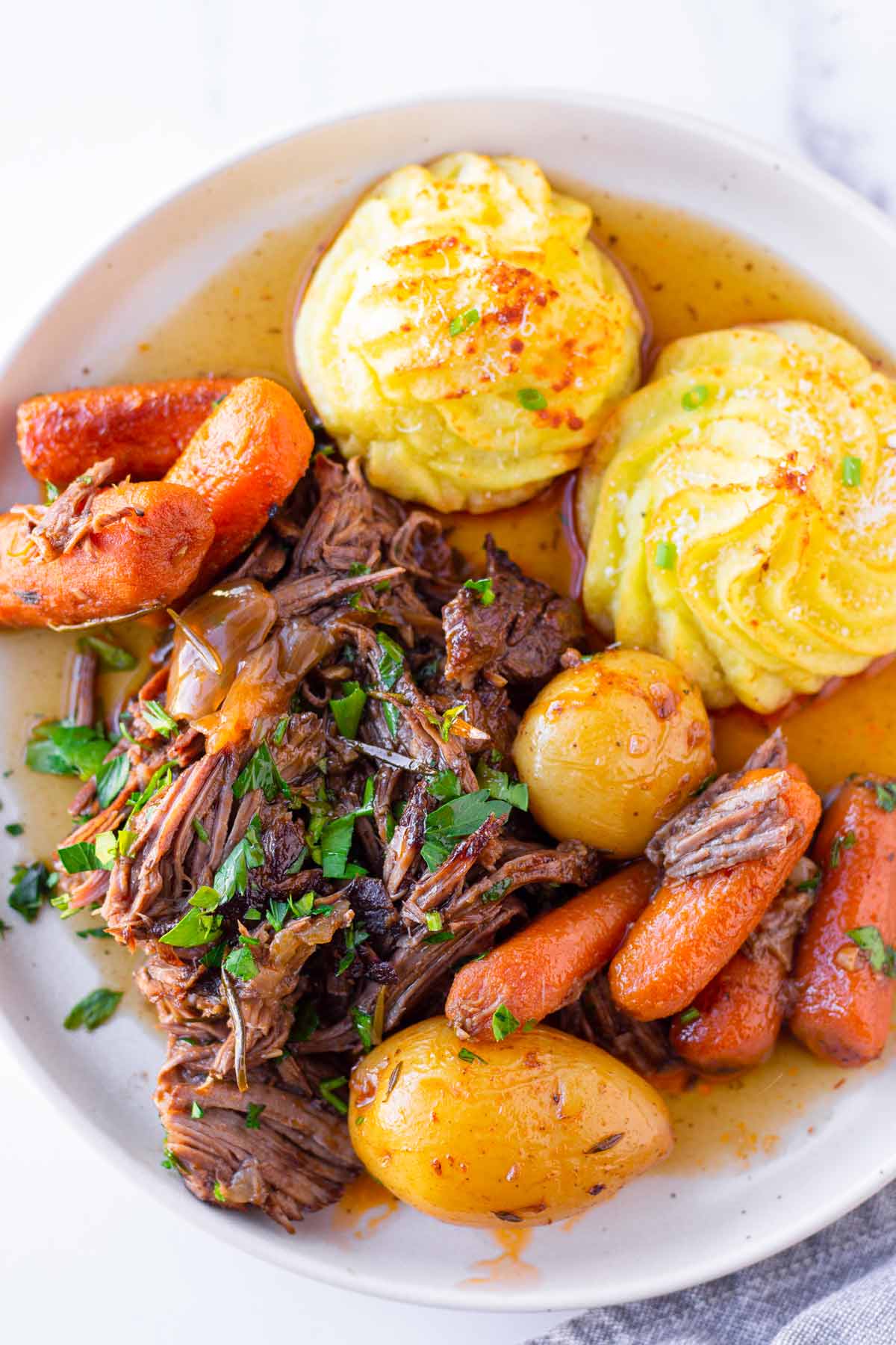 pot roast with vegetables and a side of potatoes