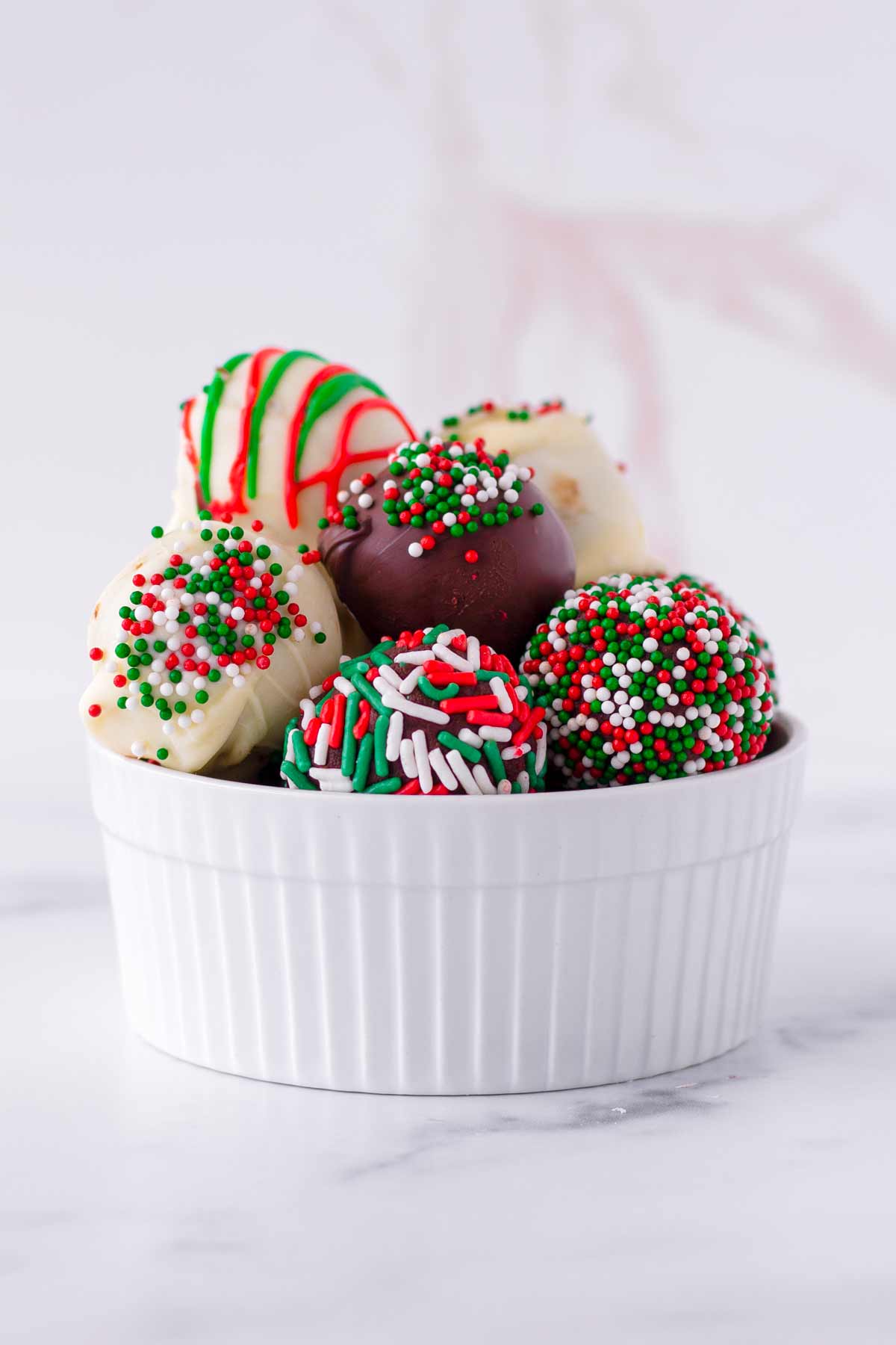 stacked chocolate truffles in a white rimmed bowl
