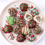 several festive chocolate truffles decorated with sprinkles on plate