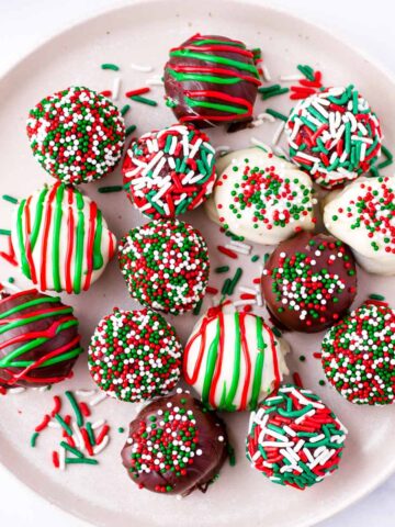several festive chocolate truffles decorated with sprinkles on plate