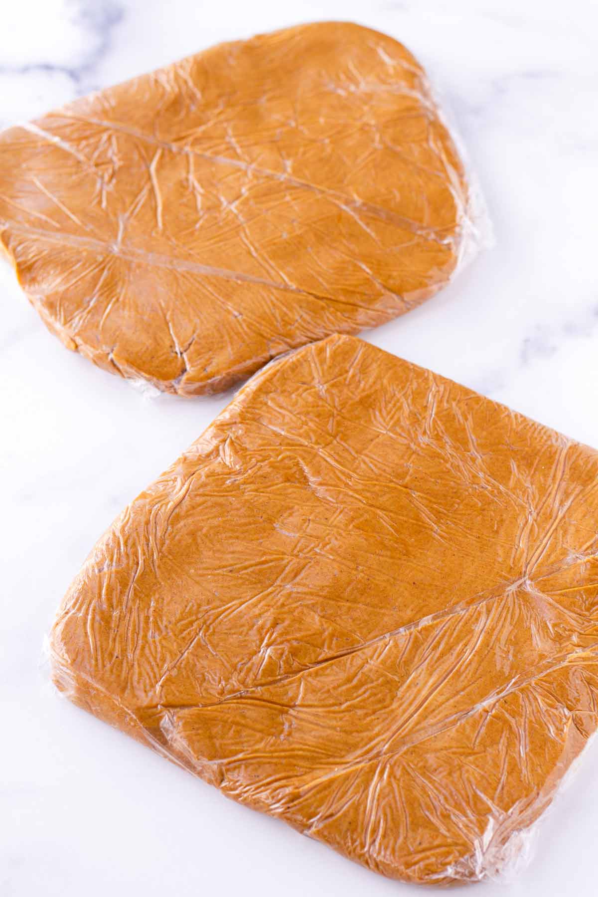 flattened disks of gingerbread cookie dough wrapped in plastic