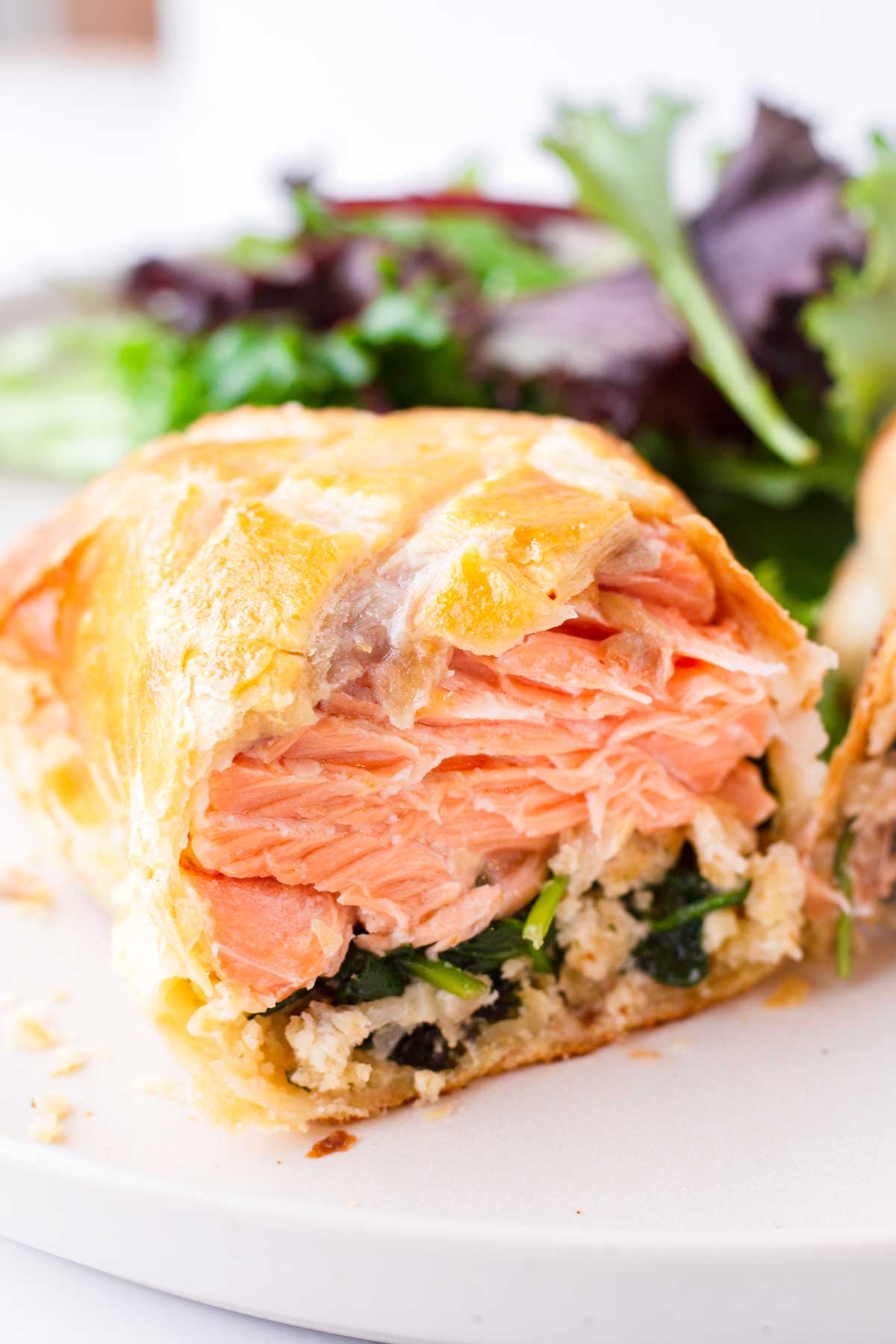 interior or puff pastry salmon en croute with spinach filling