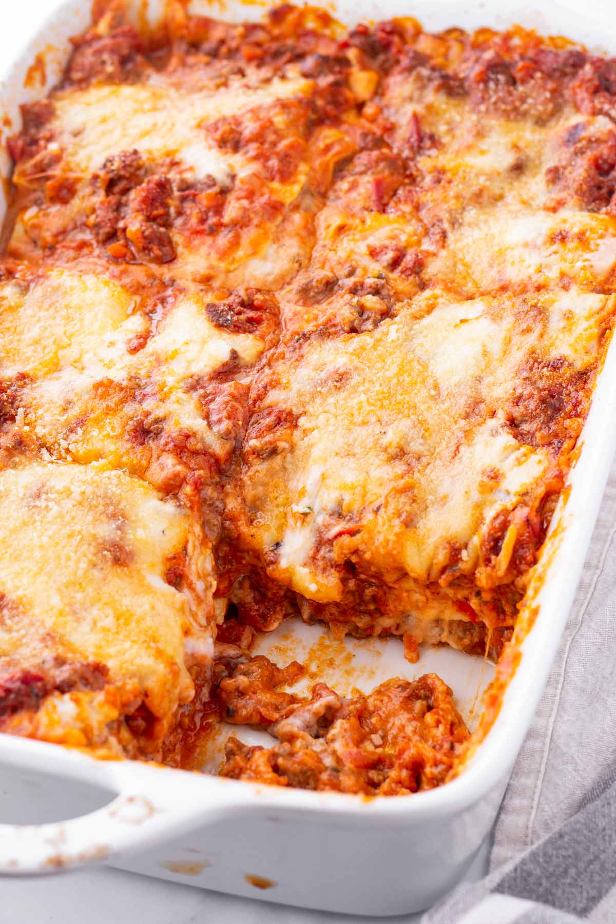 baked lasagna bolognese in a white baking dish
